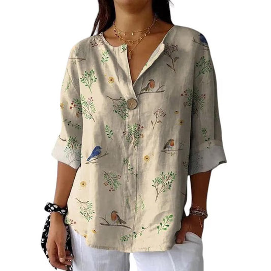 Woman wearing a floral patterned shirt with birds and plants on a white background